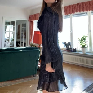 Festklänning med glittriga trådar - Svart klänning från &Other Stories med blåa och guldiga trådar i tyget som ger en otroligt fin reflektion i ljuset. Volanger på bröstet framtill, axlarna och längst ner samt ballongärmar. Lite tajtare vid midjan vilket ger en väldigt fin figur. Storlek 36 och jag skulle säga att den är true to size. Använd ett fåtal gånger och det finns inget att anmärka på skicket. Modellen finns inte kvar. Nypris runt 600kr. Mitt pris 250kr. 