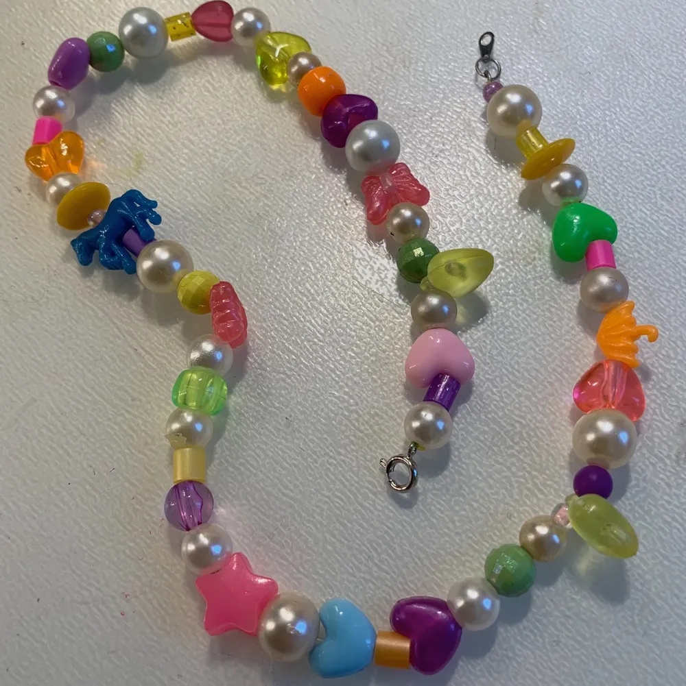 Halsband med olika färgglada pärlor och vita skimriga pärlor🌟🌈. Accessoarer.