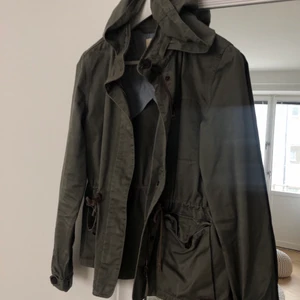 Levis militärgrön jacka strl.M - Köpte den här jackan för några år sedan men är knappt använd och det är därför jag säljer den. Känns att den är rejäl i kvaliteten och den är i fint skick! Jag är 167cm och jackan går precis till rumpan, så den är kort i passformen. Fraktkostnad ingår ej i priset.