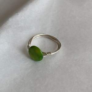 Handgjord ring med grön pärla. Tråden är silverpläterad. 18mm i innerdiameter. Fri frakt.