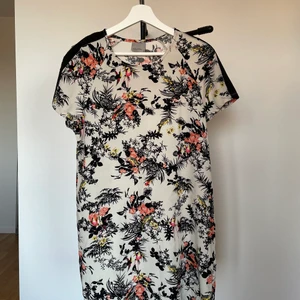Klänning - Supersöt sommarklänning i blommigt tyg! Säljer då den inte kommer till användning. Frakt tillkommer!