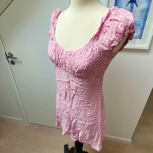 Klänning med öppen rygg - Rosa jättesöt klänning med vita små blommor på! Väldigt enkel men ändå superfin klänning som går att ha till alla möjliga tillfällen! Går att stryka (ej strykt på bilden) :-) 💕💕💕 använd en gång så i väldigt bra skick💓💞💕