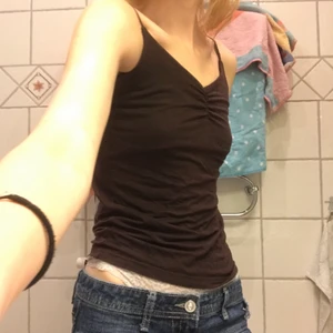 Brunt linne  - Brunt linne med sån klyfta ”tanga” åtspännande fram. Skulle gissa på storlek xs-s men är väldigt stretchigt så passar oavsett bröststorlek! Köpt second hand