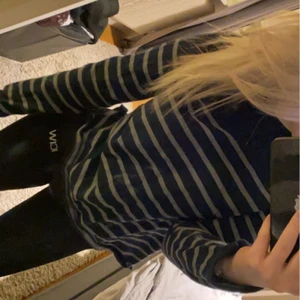 Mysig stickad randig tröja stl xs 90s  - En jättemysig stickad randig tröja från dobber på 90 talet. Marinblå med gråa randiga sträck, även en kedja på ena axeln. Finns även ett litet emblem längst ner på tröjan. Kom privat för mer bilder och frågor ang tröjan!🥰🥰