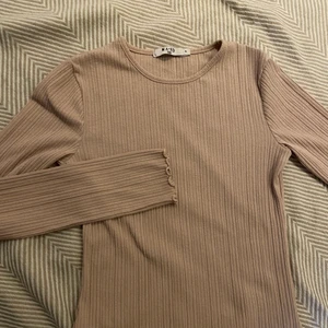 Beige ribbad långärmad - En beige ribbad tröja med ”volang” i ärmarna och längst ner på tröjan från nakd i strl M🤎