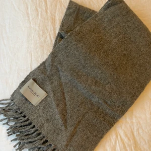 Ullhalsduk  - Halsduk i grått ull som är sparsamt använd. 