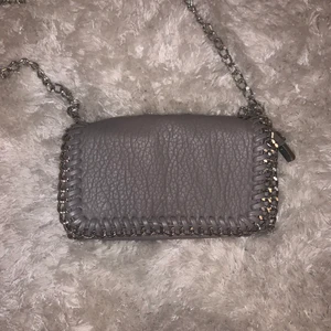 Tiamo väska  - Säljer denna grå väska från tiamo då den inte kommer till användning. Köpt här på Plick för ett tag sedan, men inte alls använd mycket. 💞 Skriv privat för fler bilder eller frågor.🥰 