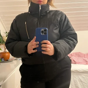 Croppad puffer - En svart puffer i kortare modell. Använt men fint skick förutom en liten slitning på armen som knappt syns (kan skicka bild vid intresse). 