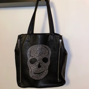 Svart väska med silvriga detaljer från Chelsea  - Fin väska som rymmer mycket saker. Använd men fortfarande i bra skick. Ett större innerfack med dragkedja med ytterligare några små fack. Små slitningar i kanten (se sista bilden). 