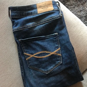 Jeans från Abercrombie and Fitch - Jeans från abercrombie and fitch i storlek 27 x 31, passar mig som har S bra. Dom har en hög midja, smal passform och mycket strech. Använda men inga slitningar förutom att tyget har blivit lite ljusare på ett stället vid gylfen (se sista bilden), därför jag säljer billigt. 