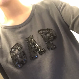 Collegetröja från GAP - Mörkgrå collegetröja från Gap. Långärmad och lite vidare i modell i storlek S. Använd men ser inte sliten ut eller så. 
