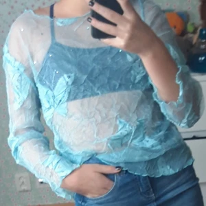 Meshtröja - Ljusblå meshtröja med fjärilar och små rhinestones. Beroende på hur känslig man är lite lite kliig. Passar xs-m beroende på vilken passform man vill ha. Gullig<3