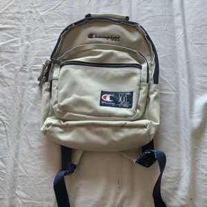 Champion ryggsäck vintage - Champion U.S.A XXL vintage ryggsäck. I utmärkt skick med alla fickor och kedjor i bra skick och fullt fungerande, använd tidigt 2000 talet sen har den legat längst inne i en garderob orörd. Längd: 32cm Bredd : 26 cm (Liten i storlek, justerbara hängslen).