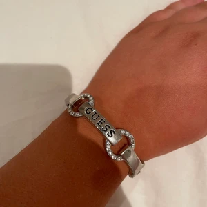 Guess armband  - Silverfärgat guessarmband med normalt slitage.
