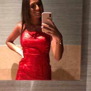 Satinklänning med öppen rygg - Jättefin röd satinklänning med band som korsas i ryggen. Klänningen är köpt på pretty little things och endast använd 1 gång. 