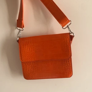 Hvisk - orange väska  - Jättefin orange väska från Hvisk i mycket fint skick. Inköpt u köpenhamn, använd ett fåtal gånger. 