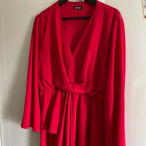 Röd klänning från BOHOOO.  - En röd och luftig sommarklänning som kommer från Bohoo och är använd ca 2 gånger. Klänningen är insydd och har en passform på en M/L funkar på en XL också beroende på hur man vill ha den.  Plaggen säljs från ett djur & rökfritt hem och köparen står för frakten som oftast ligger mellan 60-100kr. Kolla in fler plagg på min sida så kan jag samfrakta! 