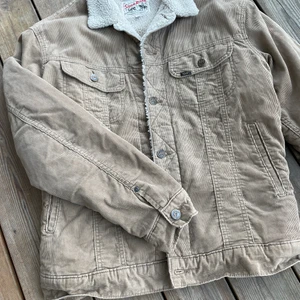 Beige Lee Teddy jacka i manchester - Lee Manchesterjacka med teddyfoder - Storm Rider. Färg: Beige, storlek M i fint skick.