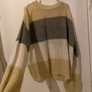 Stickad tröja - En tunn stickad tröja. Beige/grå/vit randig. Skickas mot frakt eller möts i gbg