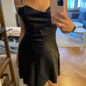 Svart satinklänning - Svart klänning från shein strl xs, justerbara band bak. Aldrig använd, nyskick! Inte struken på bilden tyvärr. Formar kroppen väldigt fint.