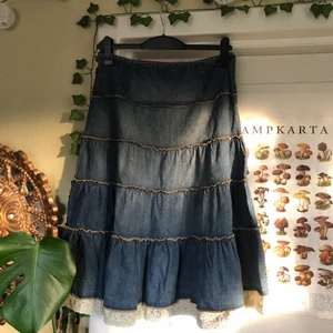 Jeanskjol - Lång blå jeanskjol med fina veck/lager samt spetsdetalj och blommigt tyg längst ner. Köparen står för frakten❣️