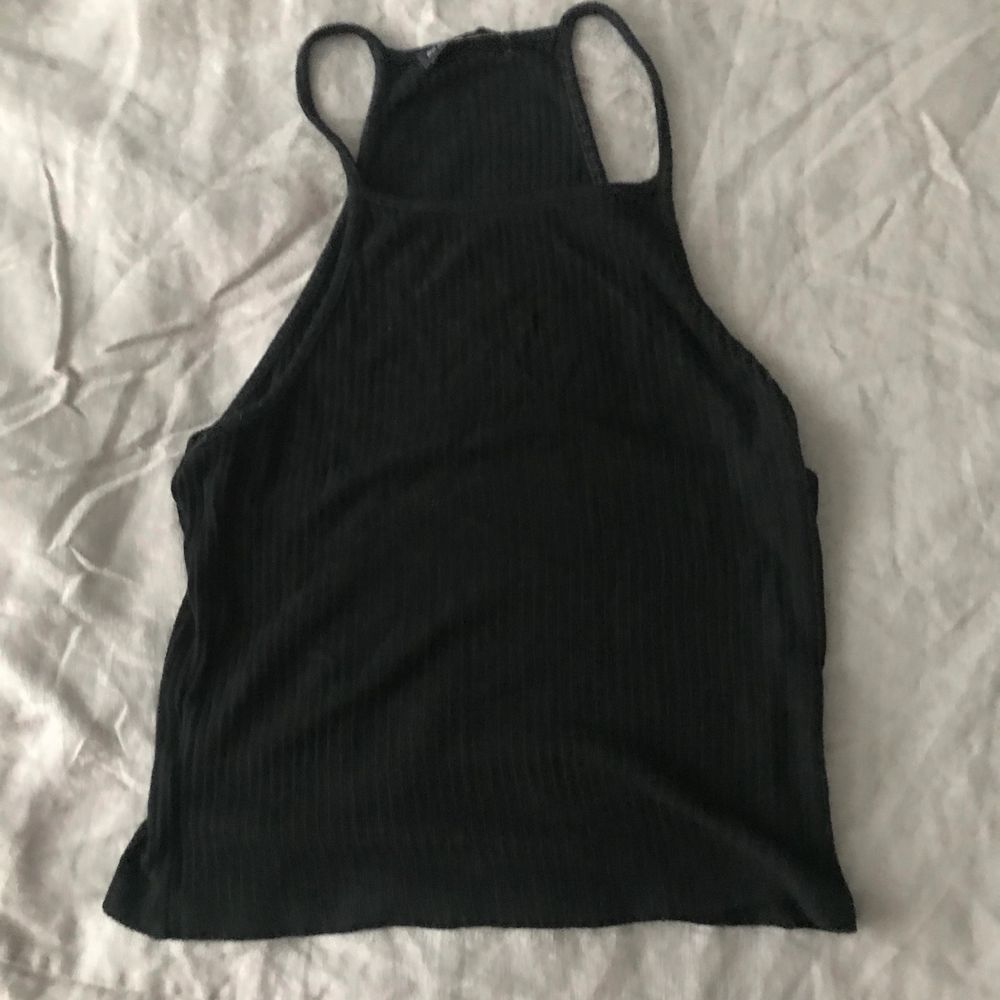 I got this from a secondhand store called Beacon’s Closet in Brooklyn. **Slightly washed out black which is reflected in the low price. Fits more like a small.** Cropped fit cutaway neckline tank in black with thin ribbed straps, made in a soft and stretch cotton blend. Racer back detail. 57% cotton 40% viscose 3% elastane. No holes, tears, rips, stains, snags. Smoke and pet free storage space. No other flaws to note. Disclaimer: Please expect some general wear in all secondhand pre-owned items as they have lived a previous life, so do not expect a mint item. . Toppar.