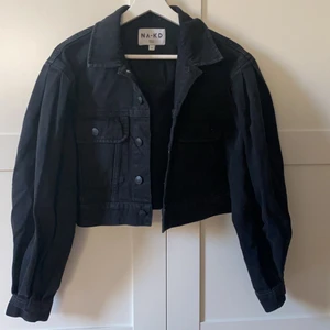 Jeans jacka  - Säljer min otroligt snygga svarta jeans jacka ifrån Na-Kd kommit till användning tre gånger därför jag säljer den. Den har puffiga  armar och den är cropad,, storlek 34 