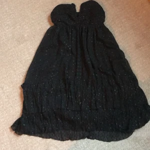 Jätte söt svart klänning  - Kort svart klänning i st 38 från hm. (Gammal modell går intr att hitta i butik) den e flowig och as härlig på sommaren, skimmriga prickar som har lite textur på tyget. Två slilkes band som man knyter i nacken för att hålla upp den. 