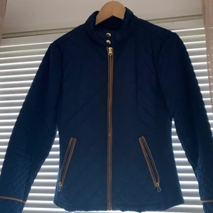 Marinblå vår/höst jacka med bruna och guldiga detaljer, så gott som ny i storlek M  - Marine blå vår/höst jacka med brun/guldiga detaljer. Jackan är så gott som ny och är i bra skick.