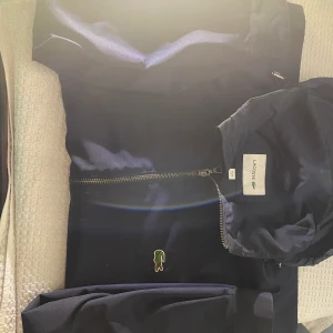 Lacoste tunn jacka i marinblå färg. - Knappt använd jacka i ett riktigt fint skick, sälj för ett riktigt billigt pris! 