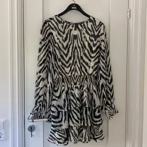 Snygg klänning med zebramönster från Gina Tricot. Klänningen har resår runt midjan samt runt ärmarnas slut. Är använd ett fåtal gånger och är i bra skick. 