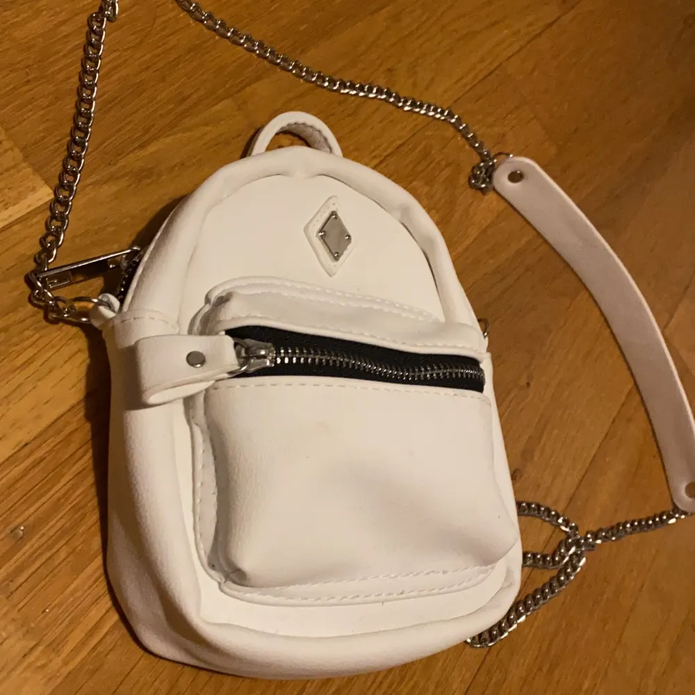 It’s a white soft faux leather like fabric. Good condition. Fits plenty. From the US.. Väskor.
