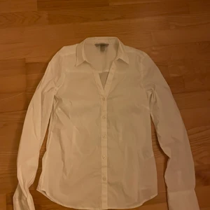 Vit Skjorta  - En vit skjorta från hm i storlek 34! Den är lite v-ringad och aldrig använd! Köparen står för fraktkostnaden!