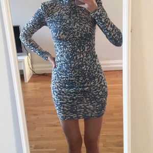 Kort klänning - Kort, tight klänning i trendigt mönster. Dragkedja där bak. Aldrig använd! 