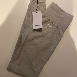 Helt nya gymshark tights! - Ett par helt nya gymshark träningstights med lapp kvar som tyvärr är för små för mig, returnerningstiden är ute och kan därför inte skicka tillbaka dom. De är i storlek Xs och är i färgen ”Light Grey Marl, nypris på dessa är 550kr jag säljer de för 400kr.