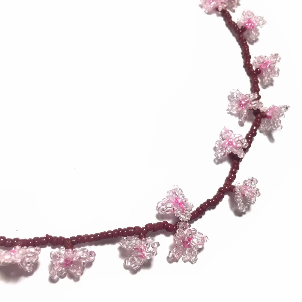 Handmade glass bead necklace with cherry blossom design. Accessoarer.