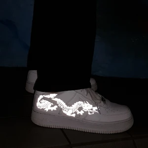 Nike AF1 Dragon - Nike AF1 med reflexmotiv "Dragon". Vi tillverkar efter beställning och alla storlekar finns därför tillgängliga. Skicka in dina skor till oss så designar vi dem för endast 299kr eller köp nya genom oss för 299kr + skokostnaden! Skriv ett meddelande till oss här eller på vår Instagram @thecustomwave.uf för att beställa🥰