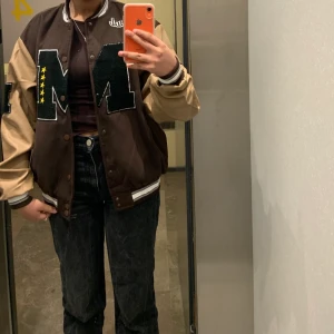 Varsity jacka - Super fin varsity/baseball jacka! Jätte fin brun färg med beiga skinnärmar. Den är i storlek L och är oversized. Om flera är intresserade så blir de bud som gäller✨