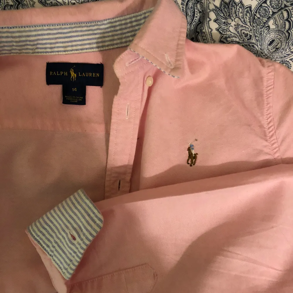 Ljusrosa Ralph Lauren skjorta i barnstorleken 14, men passar mig som brukar ha XS! Köpt för ca 800kr och använd väldigt få gånger. Som nyskick! Frakt 66kr spårbar, men kan även mötas i Stockholm 🌟 ✌️. Skjortor.