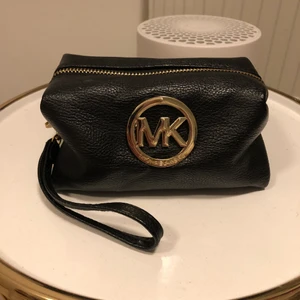 Michael Kors svart skin nessicär  - En liten svart skin nessicär från Michael Kors, använt kanske 1-2 ggr sen så har den bara legat bredvid sminklådan. Köpte den för drygt ett år sen kanske men ser typ ny ut ändå. Jätte simpelt om man vill packa ner lite smink när man ska iväg och inte vill ta med sig en stor väska och lägga allt smink i.