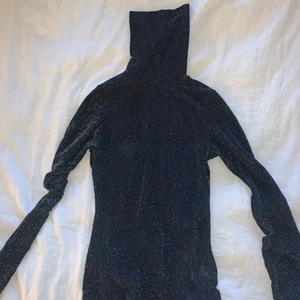 Glittrig polotröja - En glittrig polotröja använd 1 gång. Fint skick!