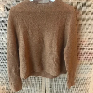 Brun Stickad tröja med hög krage - Mysig stickad tröja från Wera. Har en hög stickad krage och faller mjukt på kroppen. Den är lite pösigare på kroppen men slutar ungefär ovanför höften. Inte använd så många gånger då jag inte tycker att färgen passar mig så mycket. Nypris ca 400-500kr