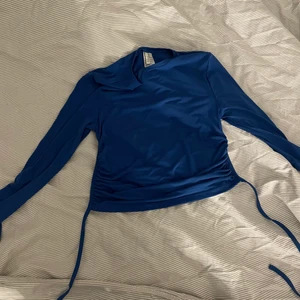 Festtopp  - Blå kort festtopp med öppen rygg och knytning 