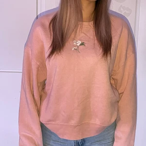 Tröja  - Rosa tröja med en broderad blomma på. Perfekt o dra på sig om man fryser lite. Lagom tjock och mjuk inuti. Hel och fint skick :)