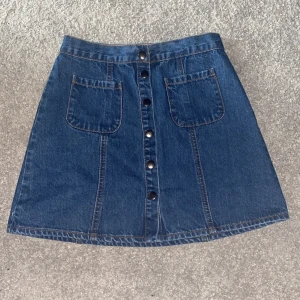 Jeanskjol - Jeanskjol med knappar och fickor. Aldrig använd, finns prislapp kvar.