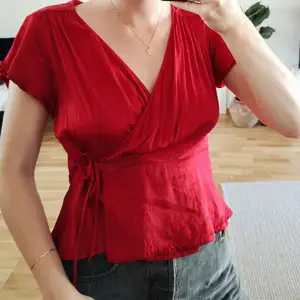 Röd blus från Zara i storlek M i omlottmodell och i fint skick. Jag på bilden är 170 cm lång och har vanligtvis 36/S i blusar.