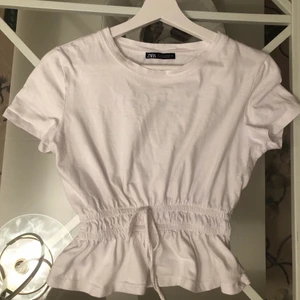 Vit CropTopp - En vit snygg croptopp med resårband runt midjan som ger en fin form på kroppen. Perfekt för att matcha ihop med par ljusa jeans till sommaren🌊☀️ Använd under 5 gånger, köparen betalar för frakten💗