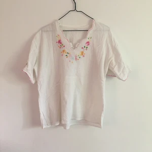T-shirt / blus M  - Fin vit sommar blus / t-shirt med brodyr. Köpt second hand och passar en M. Liten slits på sidorna. 
