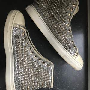 Coola philipp Plein sneakers i unisex modell passar 39/liten 40. Dom är i bra skick och har allt glitter och alla nitar kvar. Endast lite skavt under skosnörena. De är för små för mig och köpta betydligt dyrare men de står bara i garderoben. 