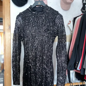 Gina Tricot - Mycket fin svart paljett klänning. Hög hals och kort. Aldrig använd!